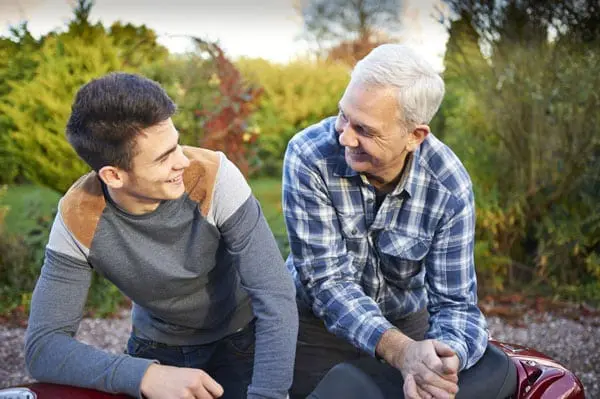 Father sitting and smiling with adult son